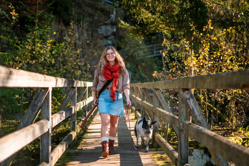 Anja mit Gitarre und Hund auf einer Holzbrücke